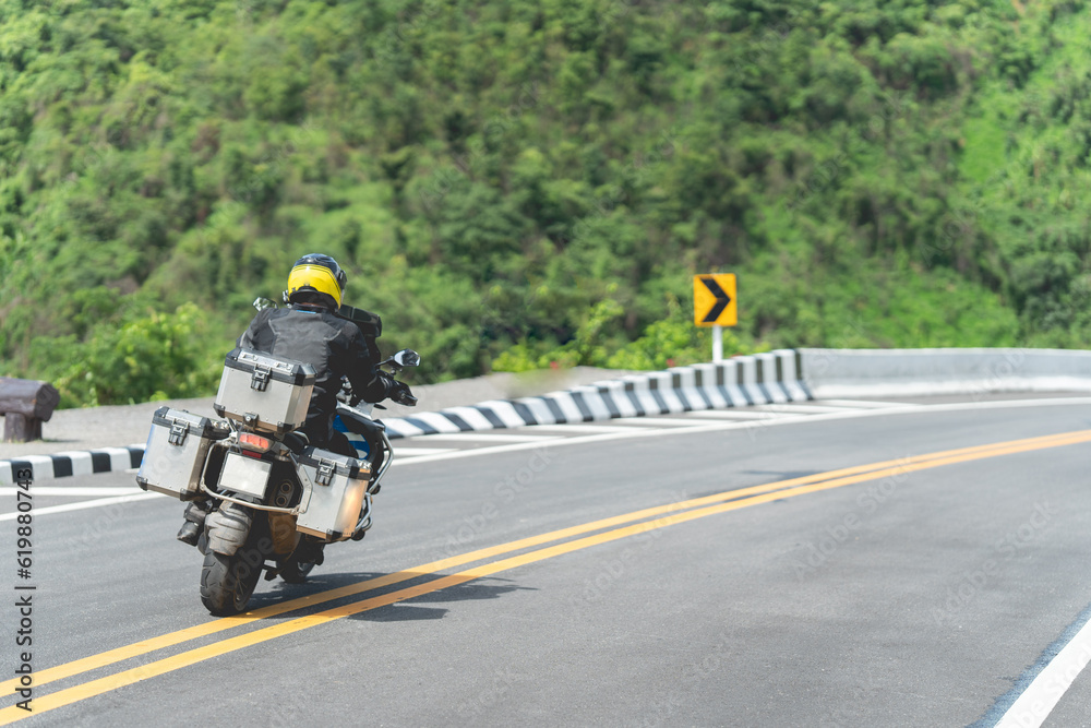 Man driving a motorcycle on a beautiful road riding Have fun riding a motorbike on the expressway. with copy space	