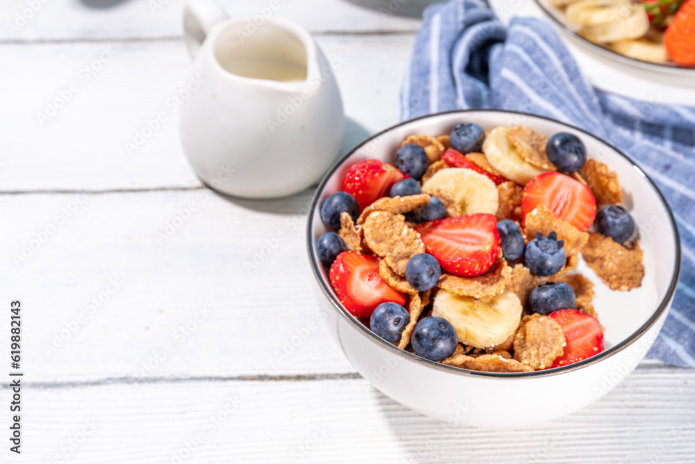 Healthy vitamin diet summer breakfast. Cereal Multigrain flakes with yogurt or milk and strawberries, blueberries, on kitchen table copy space Healthy vitamin diet summer breakfast. Cereal Multigrain flakes with yogurt or milk and strawberries, blueberries, on kitchen table copy space