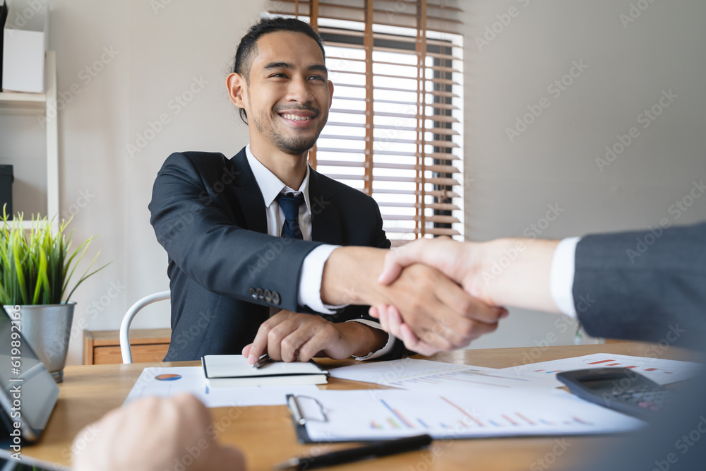 hand of client and banker shaking hands on the meeting table after business investment budget done hand of client and banker shaking hands on the meeting table after business investment budget done