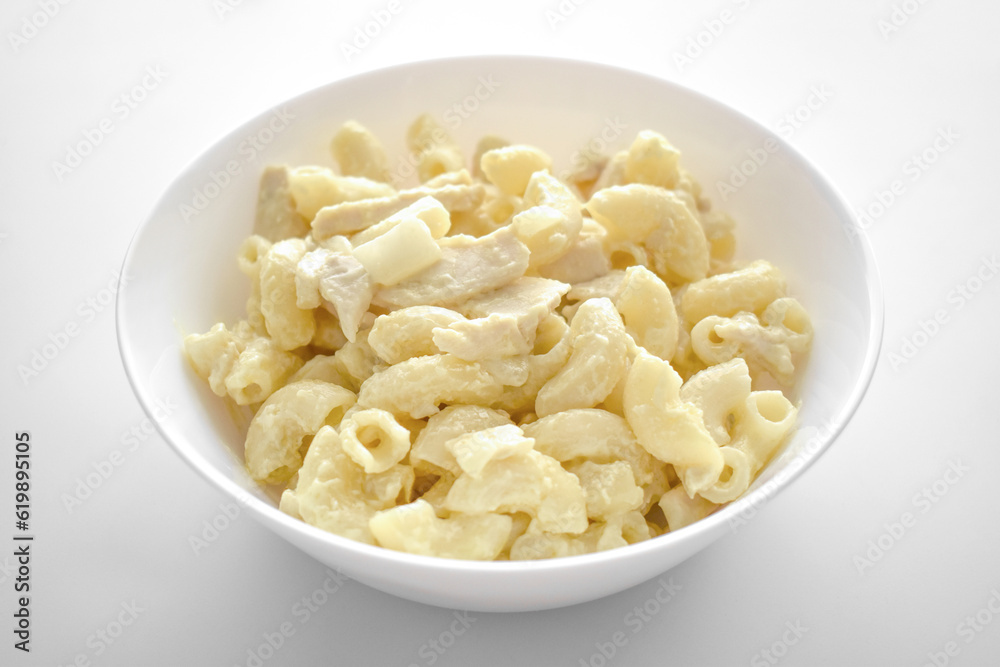 Creamy chicken pasta in a white bowl. 