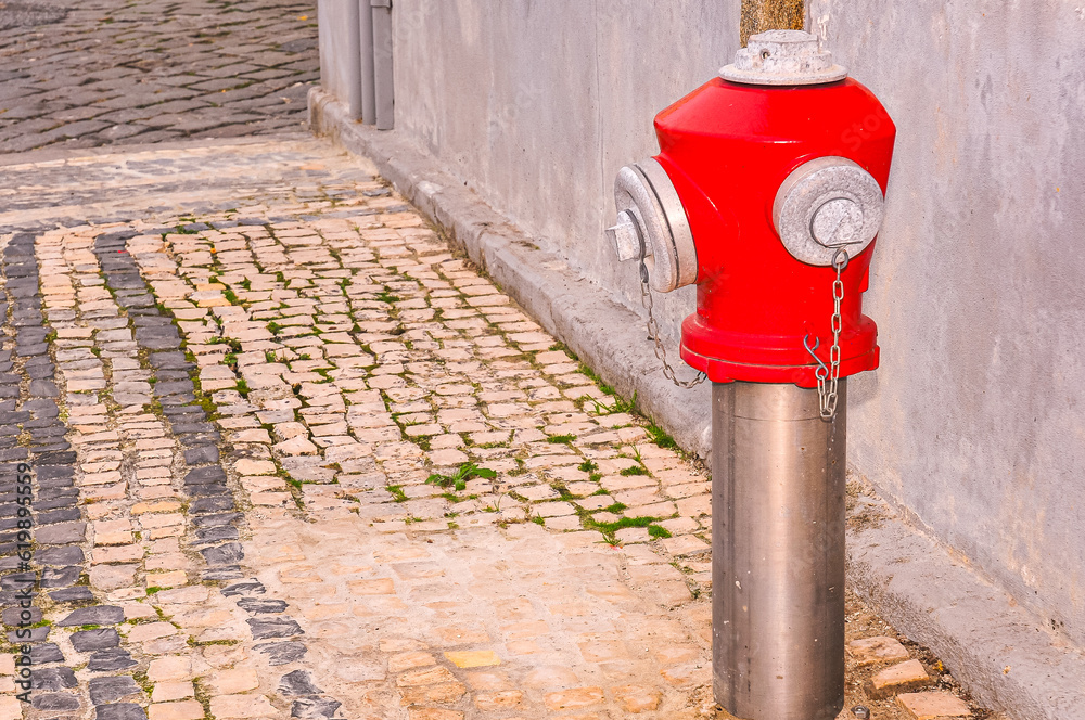 Side view, medium distance of, a fire hydrant on cobble stone street corner of, Sines, Portugal Side view, medium distance of, a fire hydrant on cobble stone street corner of, Sines, Portugal