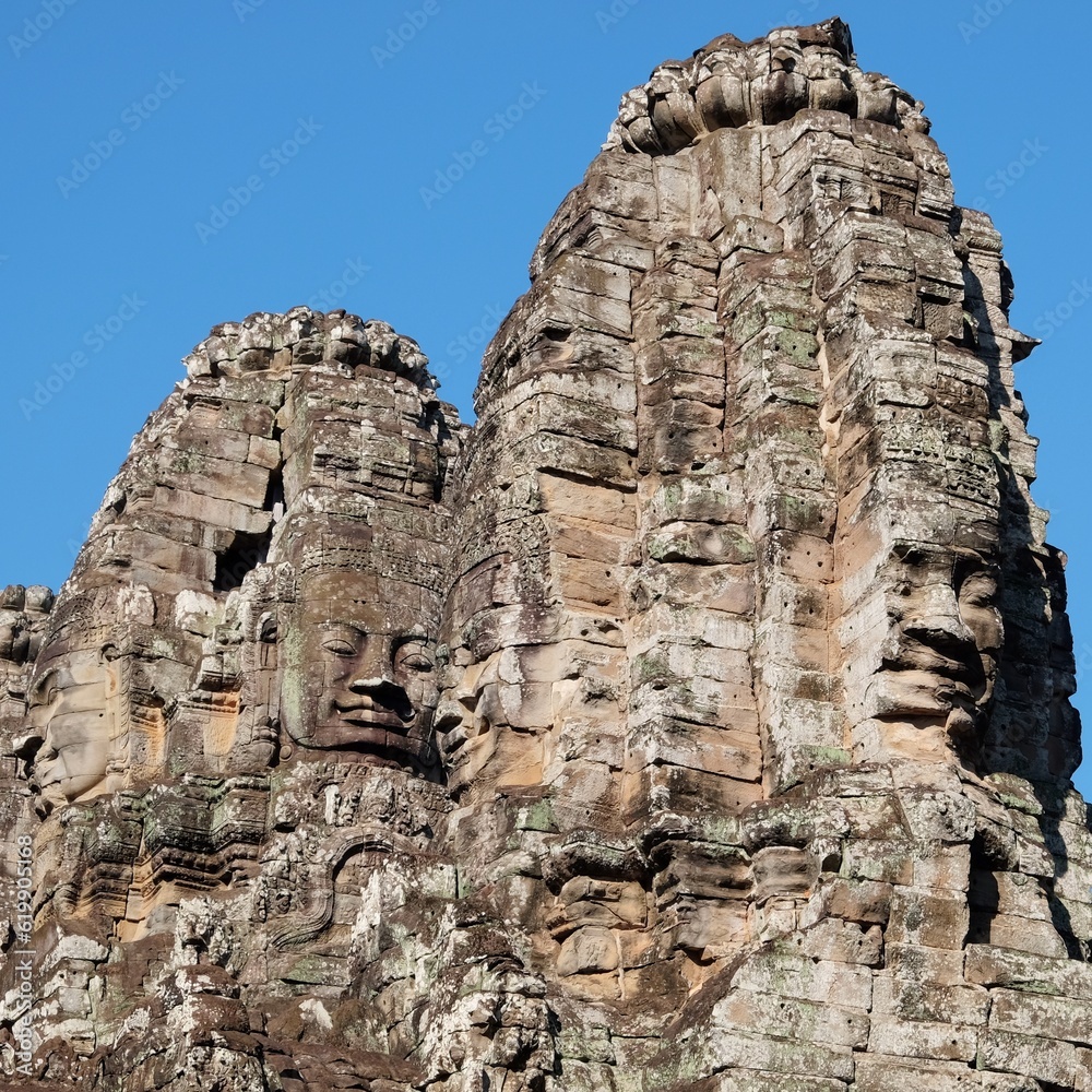 Image showcasing stone human faces on the towers of the Khmer Bayon Temple.