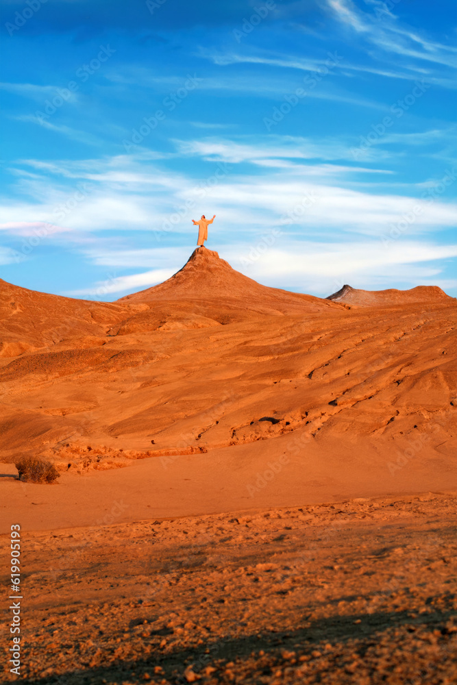 Jesus praying alone on a hill in a desert at golden hour. Biblical concept.