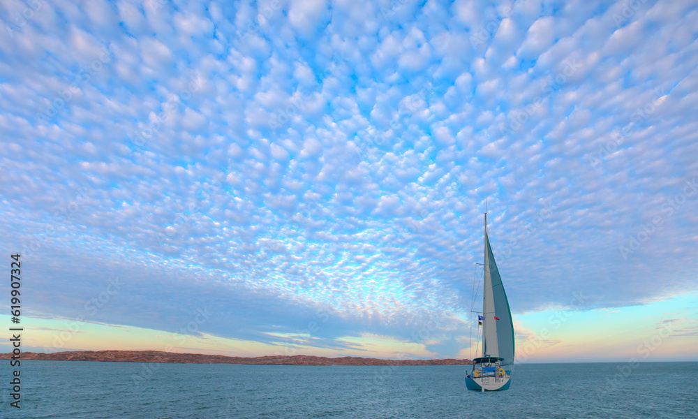 Lonely yacht sailing in the Mediterranean sea at amazing sunset - Sailing luxury yacht with white sails in the Sea.