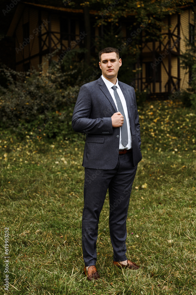 portrait of the groom outside in the autumn season.stylish tall groom in a blue suit.businessman in nature. portrait of a successful man portrait of the groom outside in the autumn season.stylish tall groom in a blue suit.businessman in nature. portrait of a successful man