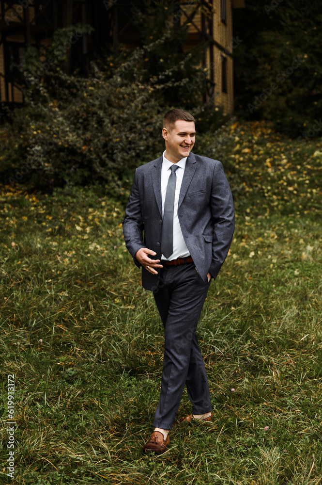 portrait of the groom outside in the autumn season.stylish tall groom in a blue suit.businessman in nature. portrait of a successful man portrait of the groom outside in the autumn season.stylish tall groom in a blue suit.businessman in nature. portrait of a successful man