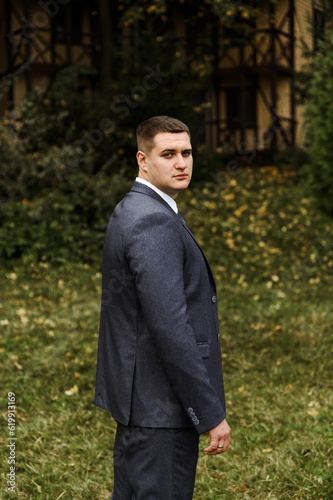 portrait of the groom outside in the autumn season.stylish tall groom in a blue suit.businessman in nature. portrait of a successful man