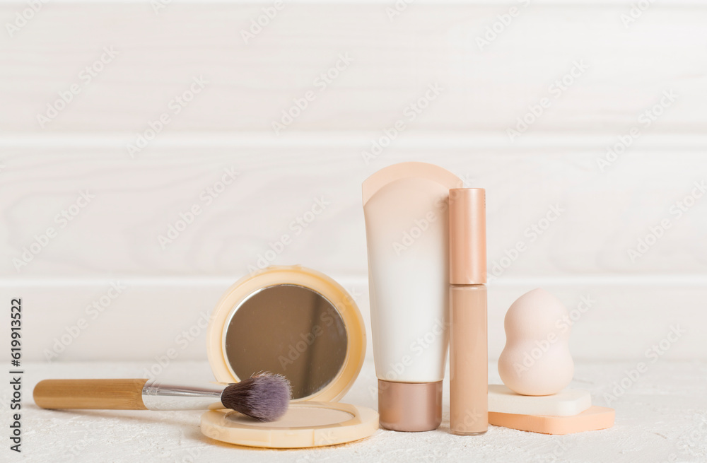 Naklejka premium Composition with makeup products for skin tone on table