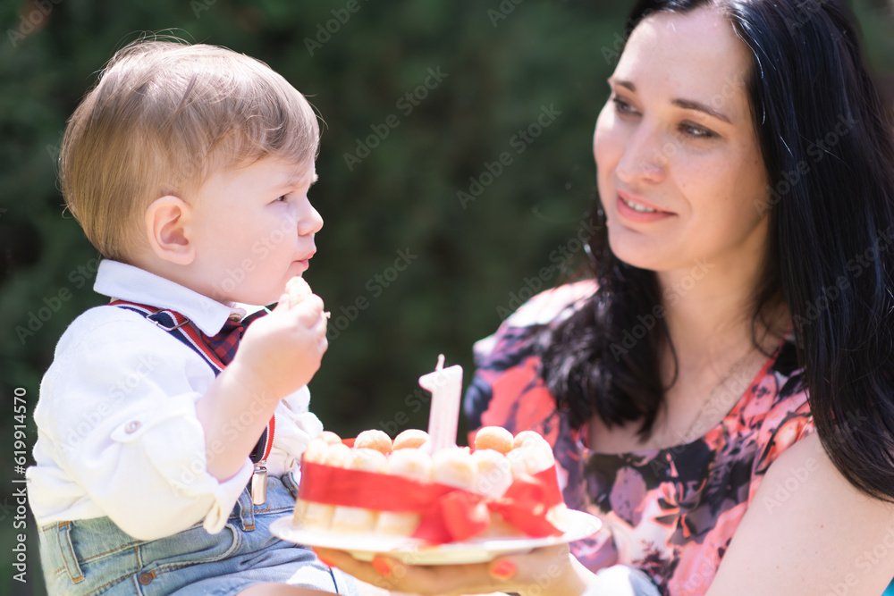 Joyous moment captured - Adorable baby boy and his mother celebrate his first birthday with a delicious cake and a single candle. Joyous moment captured - Adorable baby boy and his mother celebrate his first birthday with a delicious cake and a single candle.