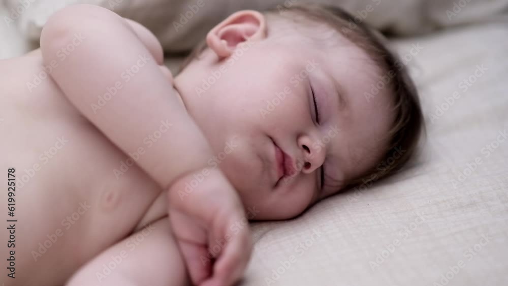 Innocent little boy sleeping spreading hands on bed with white sheet in nursery tiny fingers of cute baby taking nap in afternoon after breastfeeding at home closeup Innocent little boy sleeping spreading hands on bed with white sheet in nursery tiny fingers of cute baby taking nap in afternoon after breastfeeding at home closeup