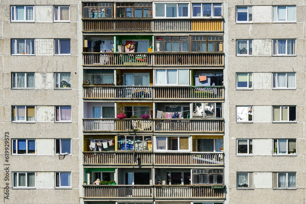 A fragment of the facade of an old apartment building in a poor area, cheap city quarter