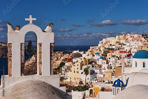 Panoramic Aerial View of Oia Village and Blue Dome Church in Santorini Island, Greece - Traditional White Houses in the Caldera Cliffs - Sunset