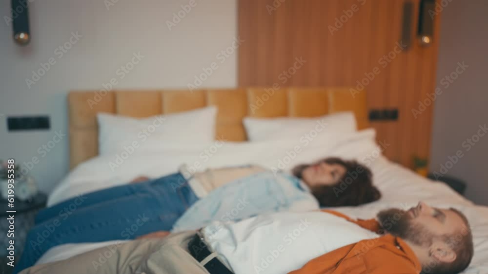 Young Caucasian man and African American woman falling tired on bed, long day Young Caucasian man and African American woman falling tired on bed, long day