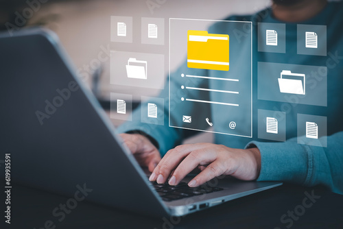 Businesswoman working on laptop with virtual screen. Online documentation database, IT consultant being set up Virtual Document Management System with a laptop, Software for archiving corporate files.