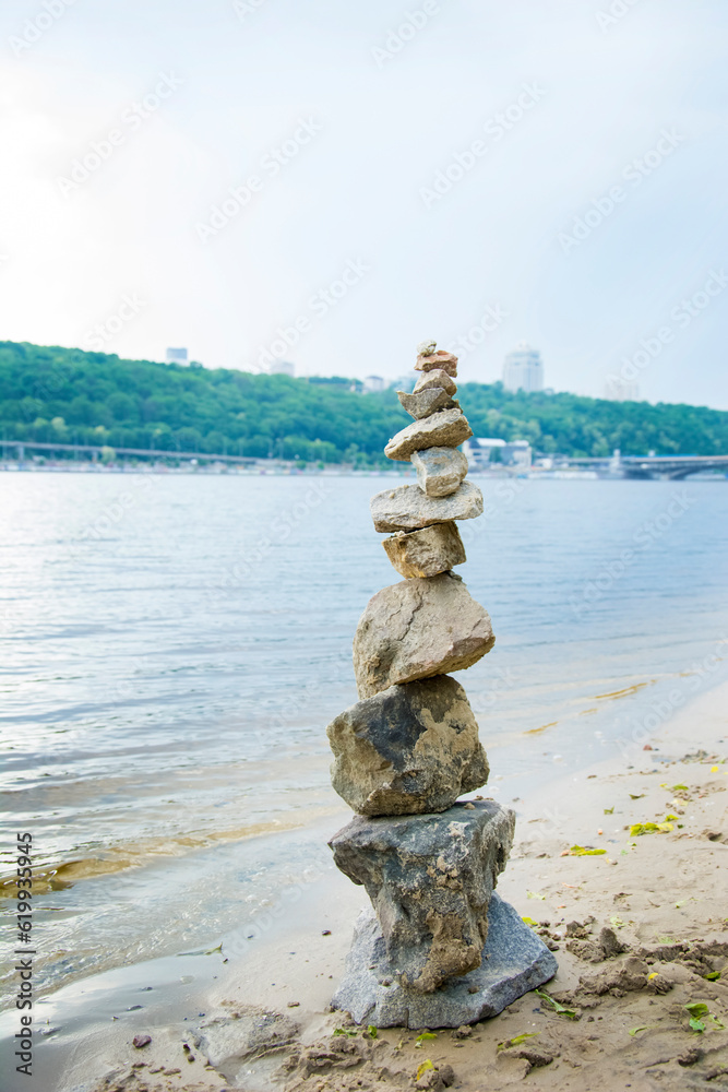 Pyramid of stones standing in the water, real natural blurred background Pyramid of stones standing in the water, real natural blurred background