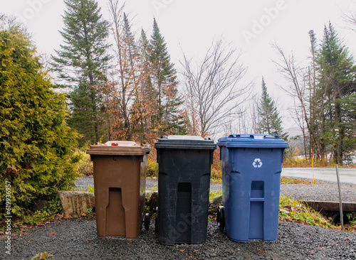 trio de bac à ordures au bord du chemin prêt à être ramassés lors d'une journée d'automne photo