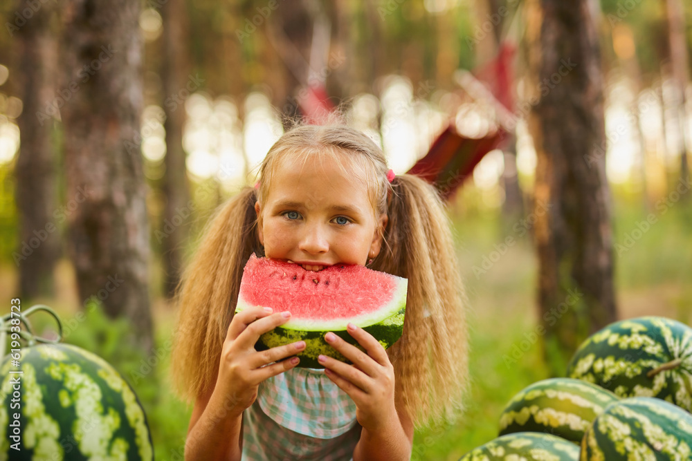 Cute girl eating watermelon at park in the forest Cute girl eating watermelon at park in the forest