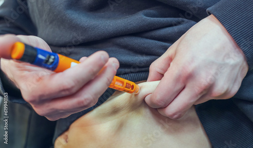 A diabetic man injecting himself with insulin before eating. Insulin injection close-up. photo