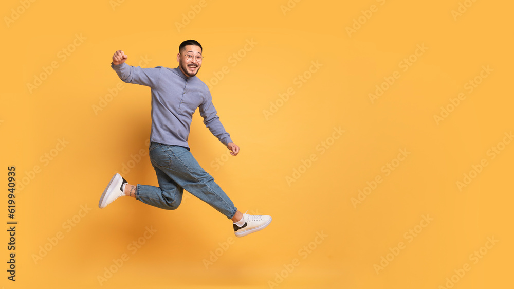 Hooray. Overjoyed Young Asian Guy Jumping In Air Over Yellow Background