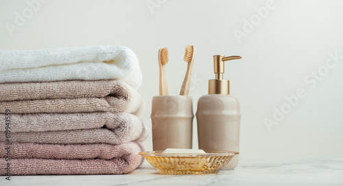 Fotografía Vintage golden bath supplies with stack of clean soft towels next to soap and toothbrushes