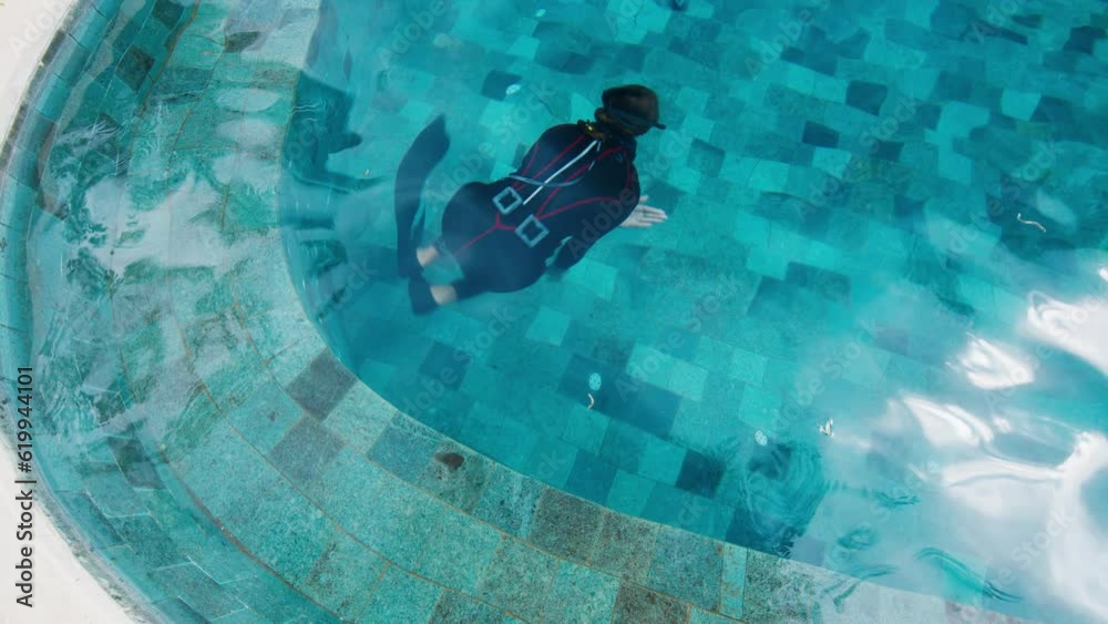Woman freediver trains in the pool and turns. Female free diver does DYN dive swims underwater Woman freediver trains in the pool and turns. Female free diver does DYN dive swims underwater
