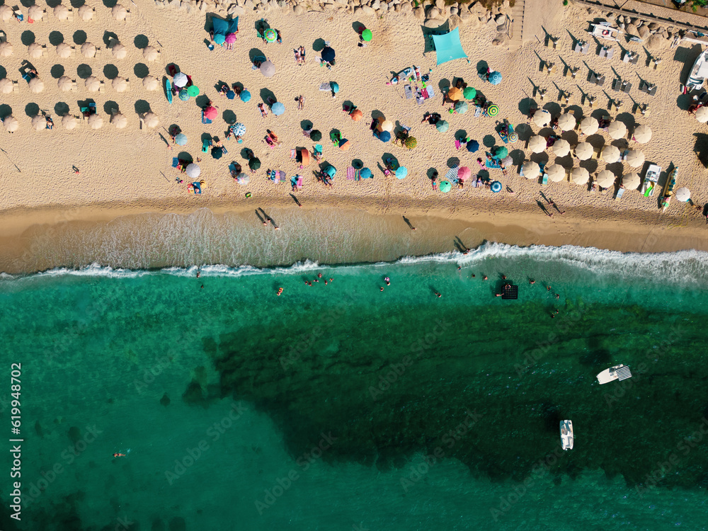 Italy, July 2023: aerial view from drone of caribbean sea and beach with tourists and umbrellas at Baia di Riaci near Tropea in Calabria
