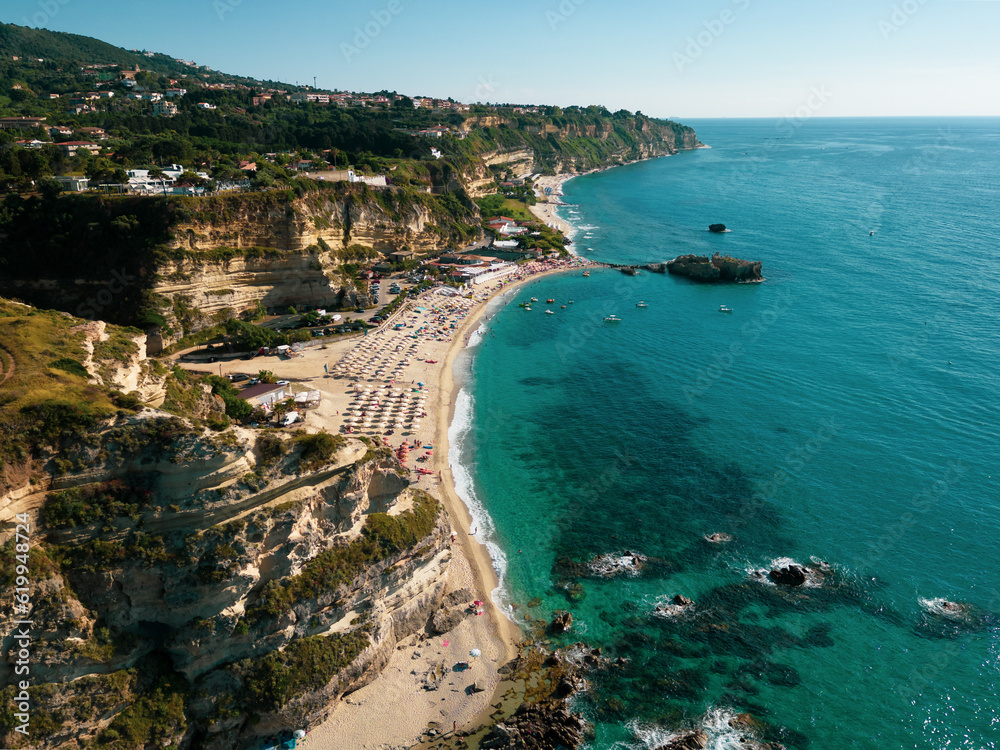 Italy, July 2023: panoramic aerial view from the drone of the caribbean sea and the cliff above the sea at the Baia di Riaci near Tropea in Calabria