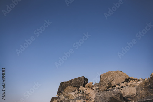 Minimalistic landscape in the mountains with stones on the slope of Mount Ararat and blue sky in the background, abstraction in the mountains