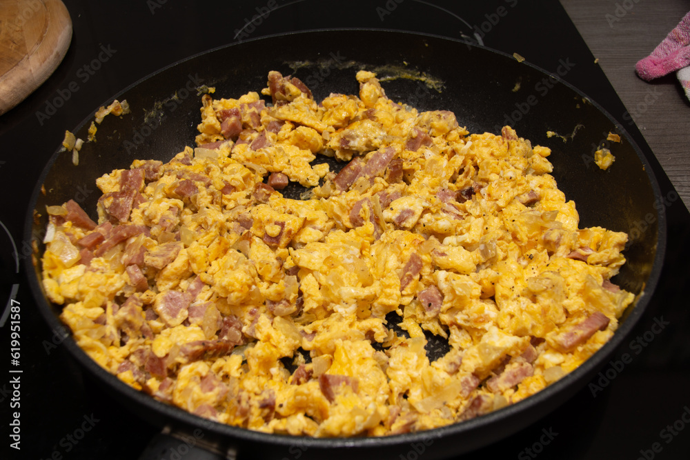 Fertige Eierspeise in schwarzer Pfanne mit Speck und Zwiebel gekocht Fertige Eierspeise in schwarzer Pfanne mit Speck und Zwiebel gekocht
