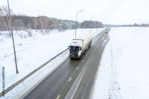 A semi-trailer truck, semitruck, tractor unit and semi-trailer to carry freight. Cargo transportation in harsh winter conditions on slippery, icy and snowy roads.