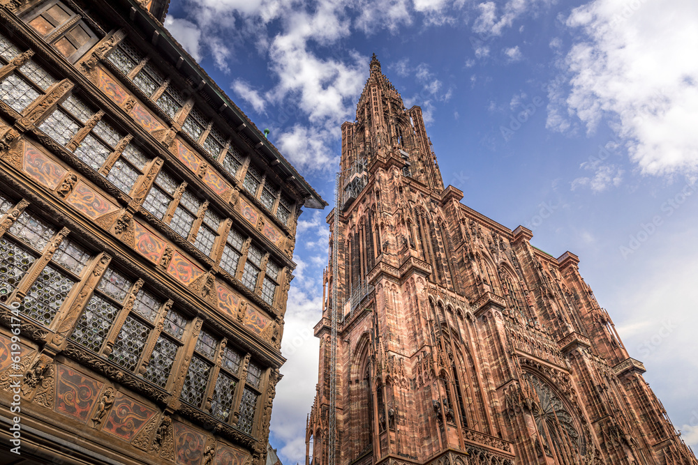 Strasbourg, France - June 19, 2023: Strasbourg Cathedral seen from the cathedral square with old half timbered houses