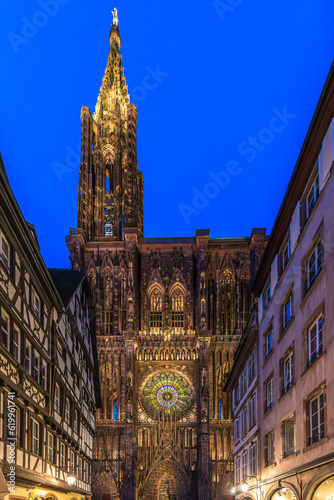 Strasbourg, France - June 19, 2023: Strasbourg Cathedral seen at night from the Rue Merciere, a pedestrian-only narrow street leading to the cathedral square. photo