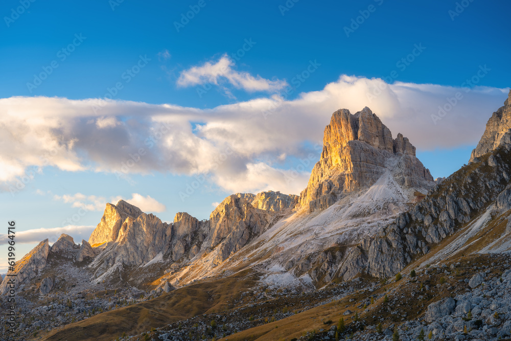 Dolomite Alps, Italy. View of the mountains and high cliffs during sunset. High sharp rocks and soft sunshine. Natural landscape. Photo in high resolution.