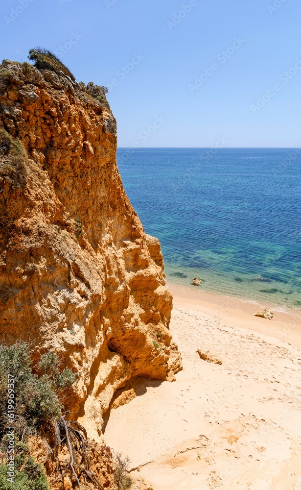 High orange cliff and the sandy beach, Algarve, Portugal
