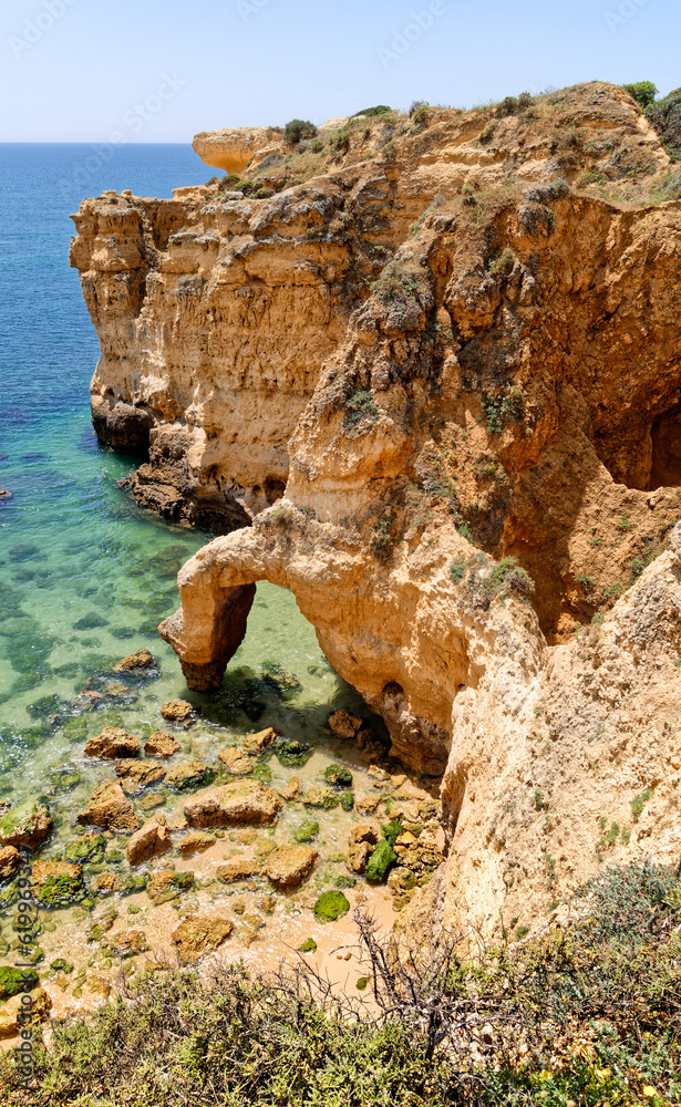 Natural arch and turquoise sea on a sunny day, beach Praia de Sao Rafael, Algarve