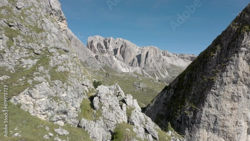 Aerial drone flying through a peaceful mountain top rock formation in the middle of an alpine meadow in the Italian Alps 01 photo