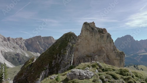 Aerial drone reveal rotation of a peaceful mountain top rock formation in the middle of an alpine meadow in the Italian Alps 01 