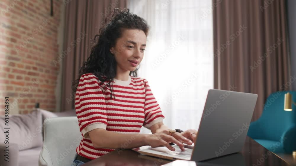 Hardworking woman actively typing information or message to her coworkers. Happy female worker using laptop for remote job. Having good feelings while freelancing online. Occupation concept. Hardworking woman actively typing information or message to her coworkers. Happy female worker using laptop for remote job. Having good feelings while freelancing online. Occupation concept.