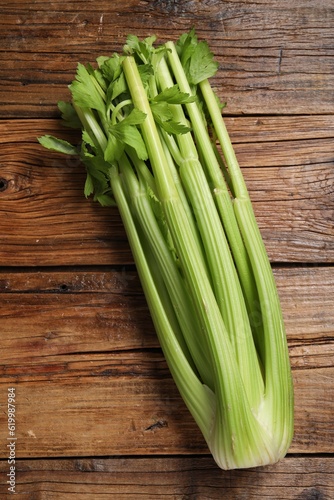 One fresh green celery bunch on wooden table, top view