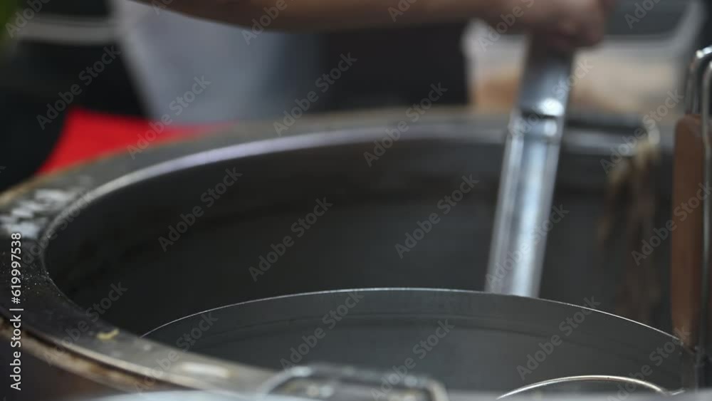 Stirring the noodles in a pot in boiling water. Stirring the noodles in a pot in boiling water.