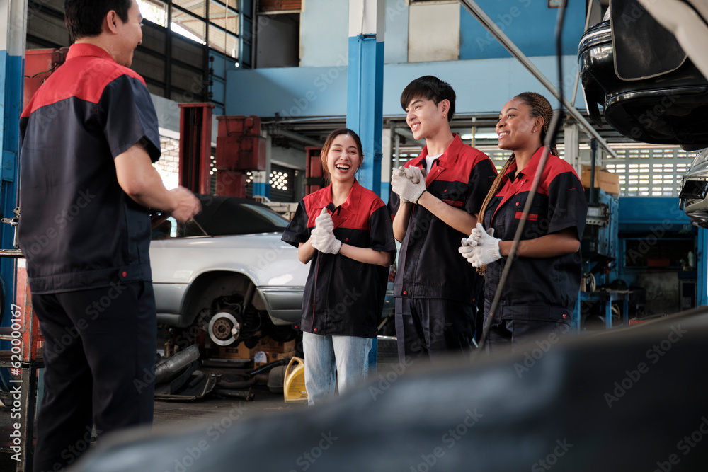 Male professional supervisor engineer and mechanic workers are cheerful with finished repair work, teamwork achievements at car service garage, and harmonious maintenance jobs in automotive industry.