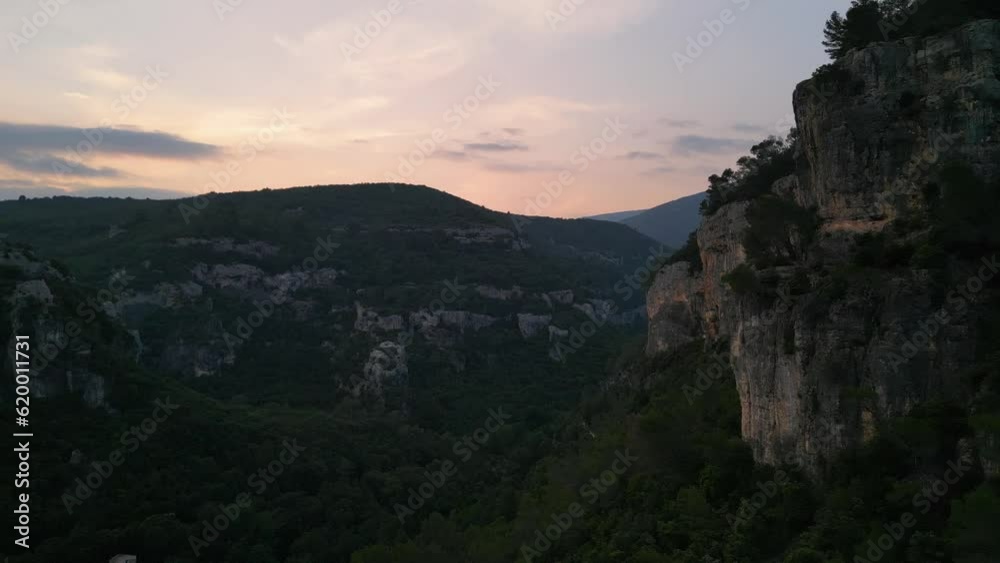 Golden hour light on steep limestone cliffs over peaceful valley Golden hour light on steep limestone cliffs over peaceful valley