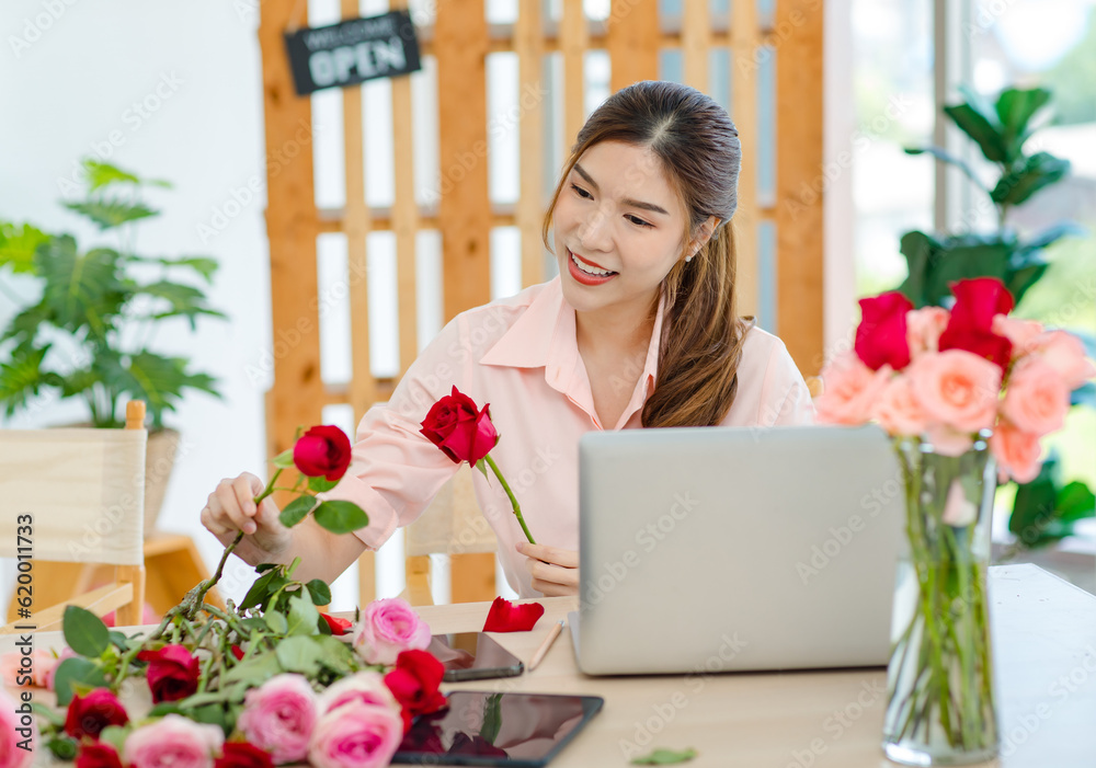 Asian professional successful female florist designer shop owner entrepreneur businesswoman sitting smiling holding decorating picking choosing red roses flowers bouquet in floral garden store studio Asian professional successful female florist designer shop owner entrepreneur businesswoman sitting smiling holding decorating picking choosing red roses flowers bouquet in floral garden store studio