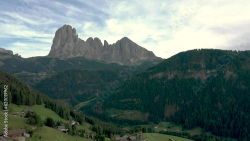 Aerial drone shot of a catholic church top cross with the Italian dolomites alps mountains in the background 02