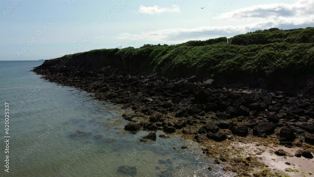 Aerial view Traeth Lligwy Jurassic rocky weathered rugged Anglesey coastal shoreline, slow push in Aerial view Traeth Lligwy Jurassic rocky weathered rugged Anglesey coastal shoreline, slow push in