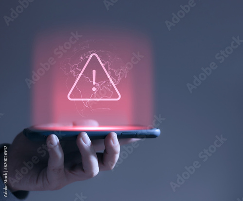 Photographie hacker attack maintenance concept and hacking cybercrime cyber security User is using smartphone with warning triangle for error notification