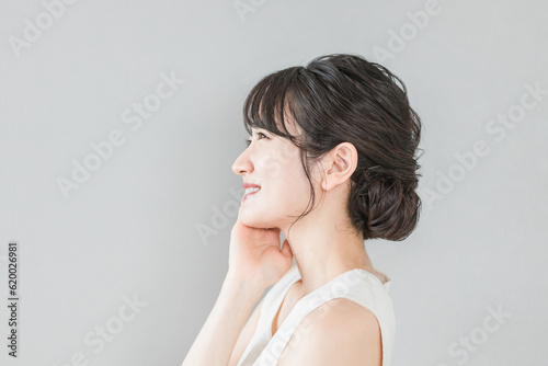 スキンケアをする美肌のアジア人女性の横顔（Eライン・フェイスライン） 
