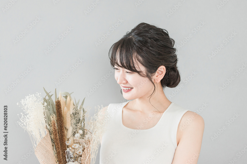 ブーケ・花束を持つ笑顔の日本人女性（誕生日・プレゼント・母の日）
