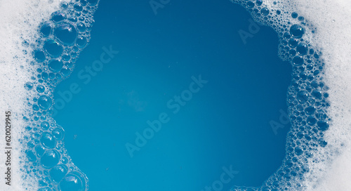 Detergent foam bubble on water. Blue background, Soap sud photo