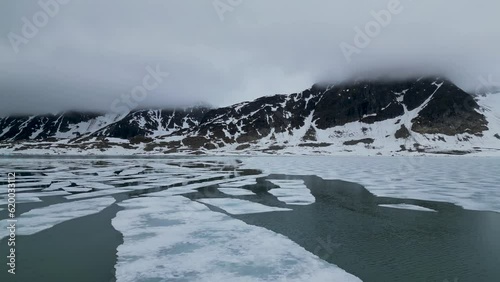 Flying over the arctic ocean by the Svalbard archipelago coastline.